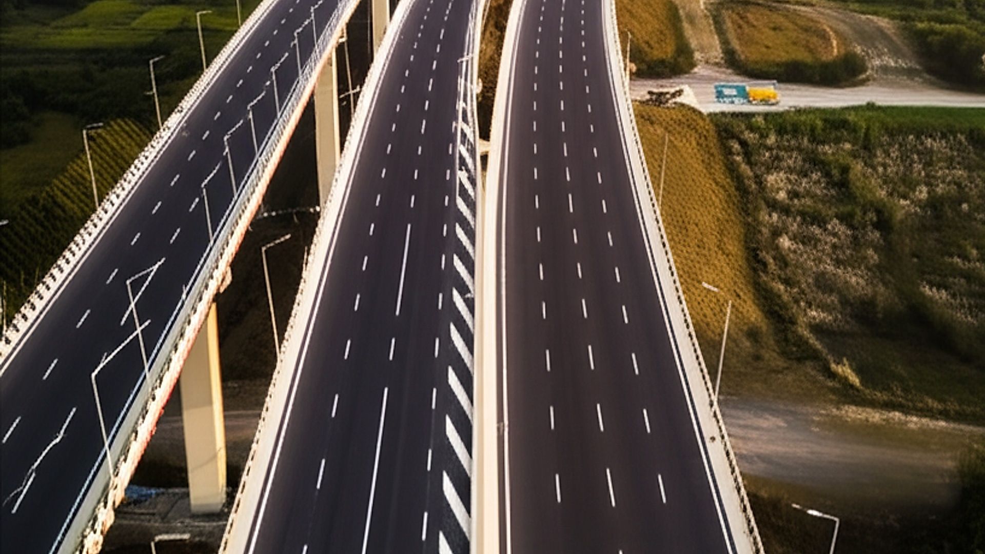 Architectural photograph of the completed section of NH-748A (4-Lane Expressway), showcasing a sweeping overpass bridge in PIU Raichur, India. Shot during golden hour, with warm, directional sunlight casting long shadows and highlighting the texture of the asphalt and concrete. Focus on the clean lines and modern design of the highway infrastructure, emphasizing scale and functionality. Professional architectural photography style with a wide-angle lens, capturing the surrounding landscape and showcasing the project's integration within the environment. Sharp focus and high dynamic range.. Professional architectural photography, ultra-high quality, sharp focus, vivid colors, dramatic lighting, golden hour, cinematic composition, 8K UHD, photorealistic.